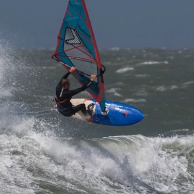 Reinoud hitting a wave on his windsurf board at Domburg