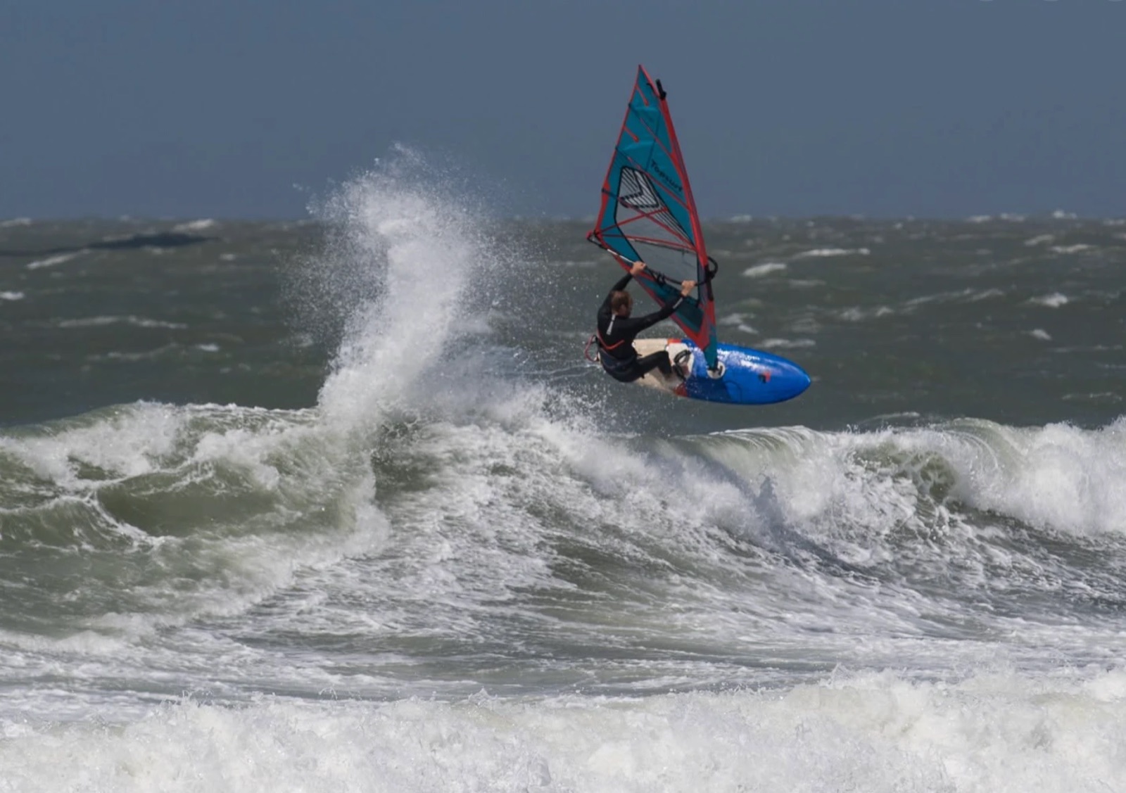 Reinoud hitting the lip of a wave on his windsurf board at Domburg